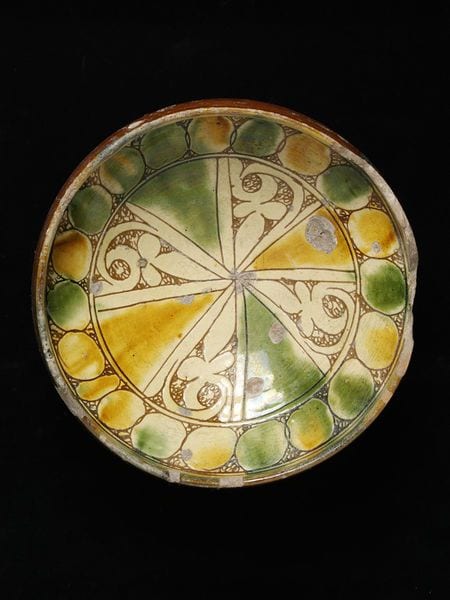 1300 1499. Bowl red earthenware covered with a white slip incised splashed in green and amber and covered with a clear lead glaze Byzantine Cyprus 14th or 15th century. Museum Number C.22 1936.